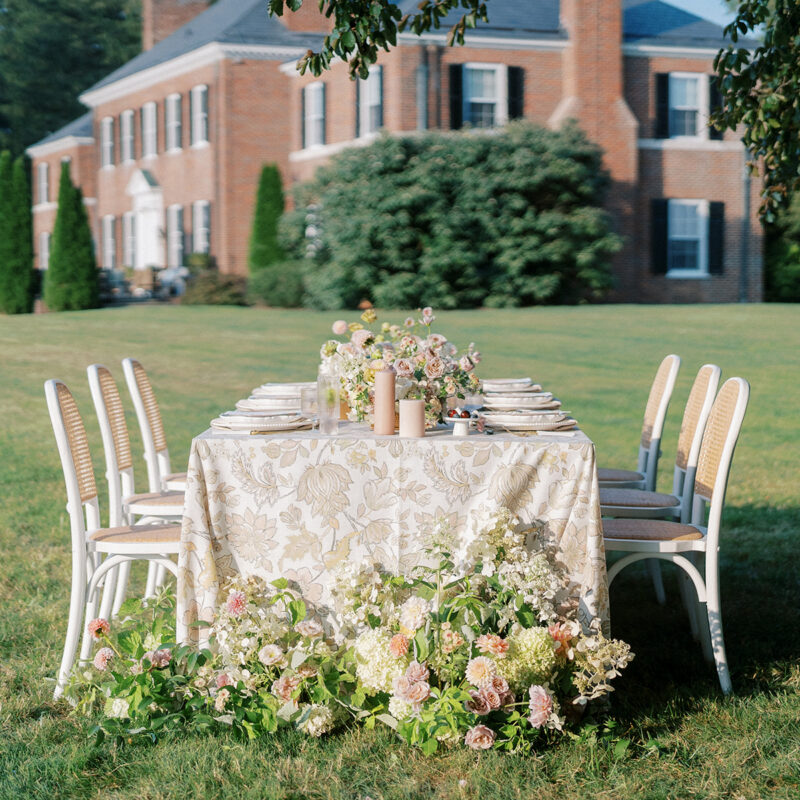 wedding reception table set up in front of brick, Georgian-style estate