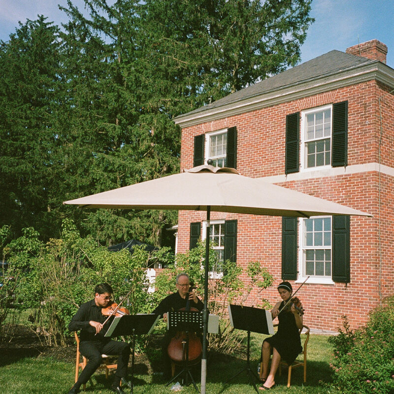Musicians playing next to brick home