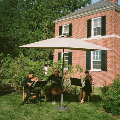 Musicians playing next to brick home